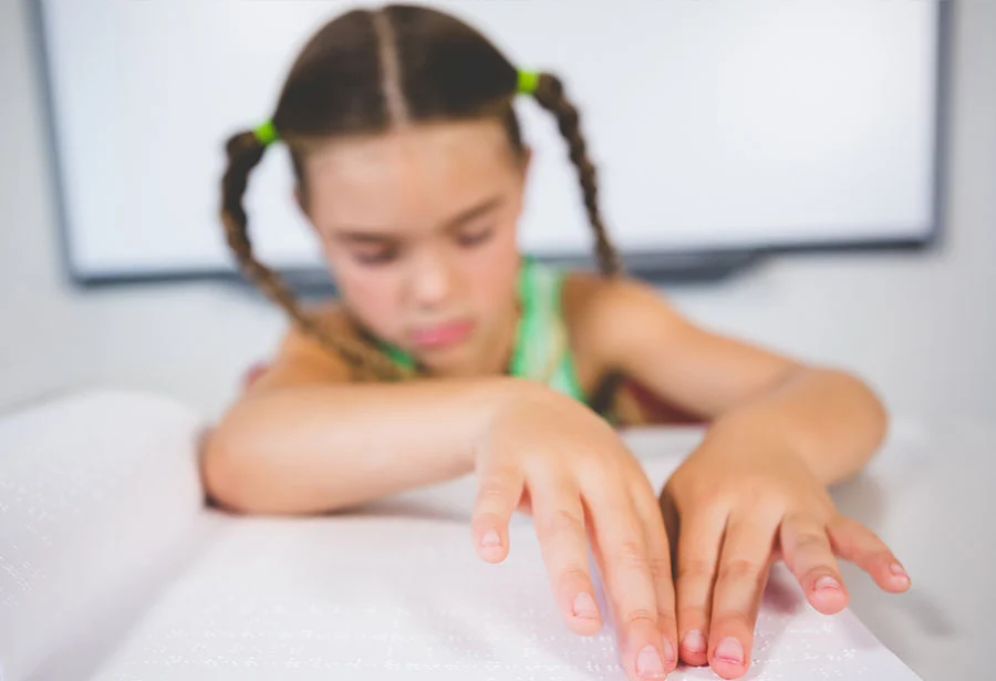 Alumna ciega leyendo un libro en braille