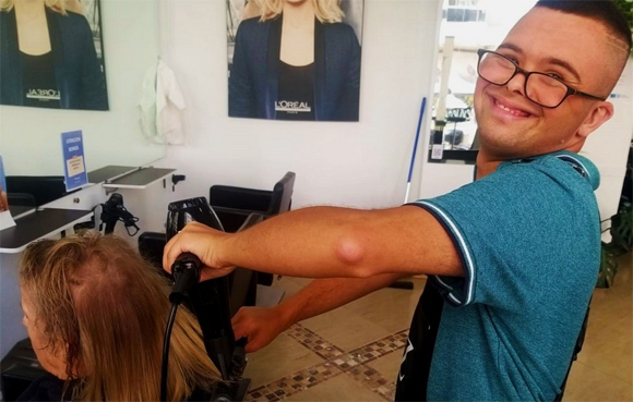 Antón Esteban, cortando el pelo a una clienta
